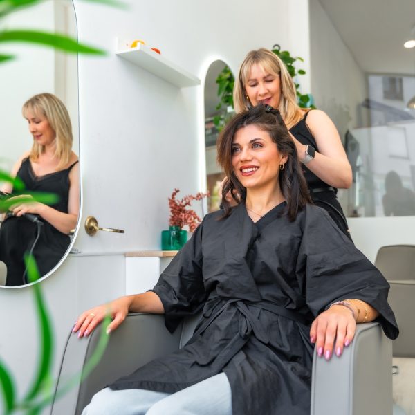 Hairdresser styling customer's hair in beauty salon